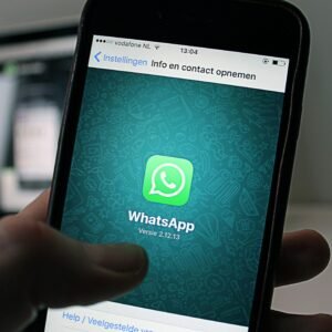 A smartphone displaying the WhatsApp application screen held by a person.